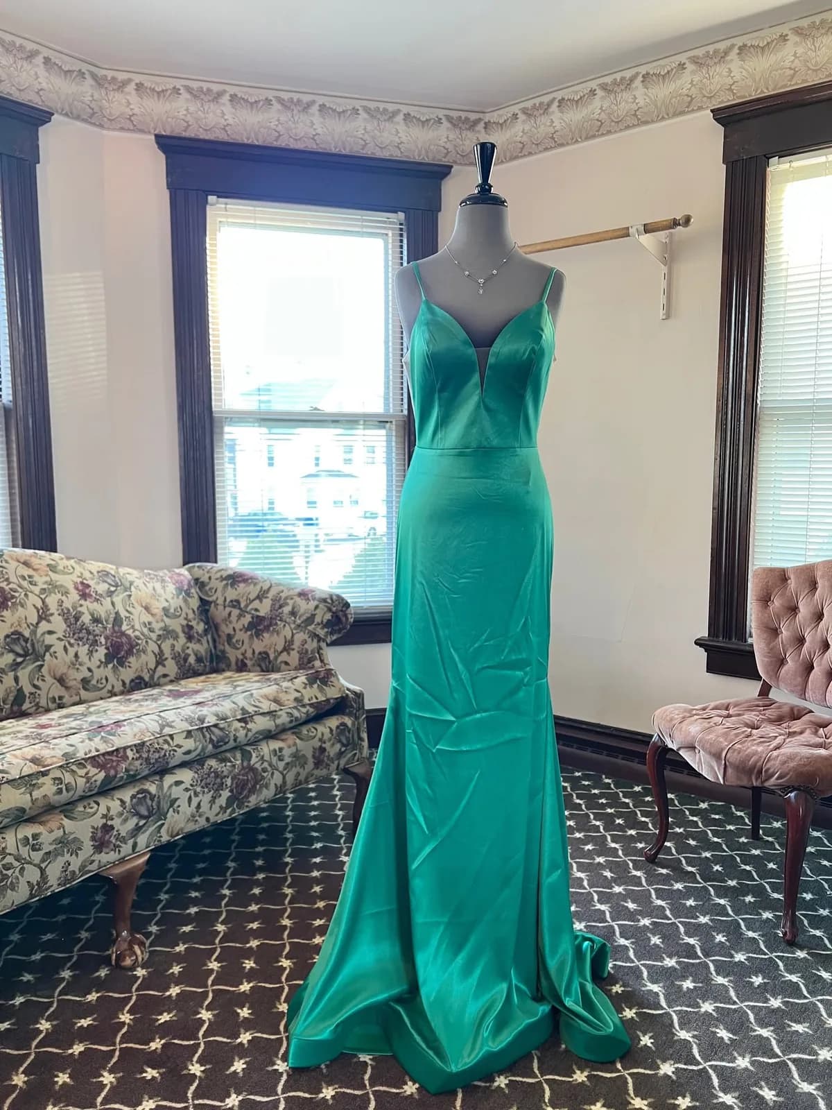 An emerald green gown on a mannequin in the shop's front room